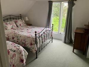a bedroom with two beds and a window at Rose Cottage in Hamilton