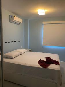 a bedroom with a bed and a air conditioner at Golden lake apartamento com linda vista para piscina in Arraial do Cabo