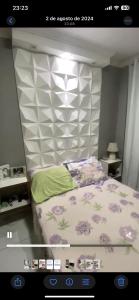 a bedroom with a bed with purple flowers on it at Apartamento em condomínio para a COP30 in Marituba