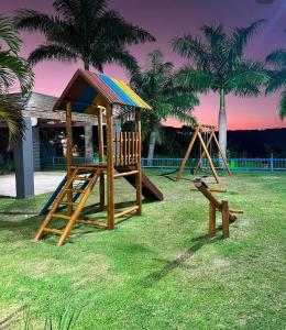a playground with a slide and a play structure at Apartamento de um quarto com varanda externa in Bananeiras