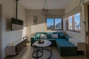 Una sala de estar con un sofá azul y una mesa. en Kolymbia Bella View House, en Kolymbia