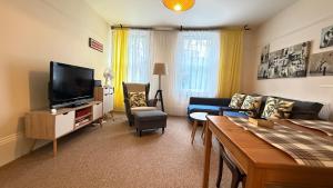 a living room with a couch and a tv at Central Located One Bedroom Apt in Bristol