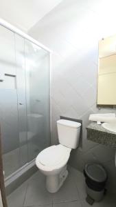 a bathroom with a toilet and a shower and a sink at Pousada Central in Feira de Santana