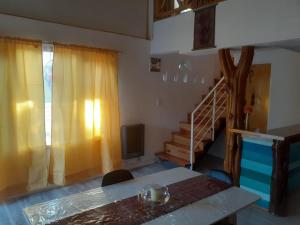 a room with a table and a television and a staircase at Lo de Pere in San Carlos de Bariloche