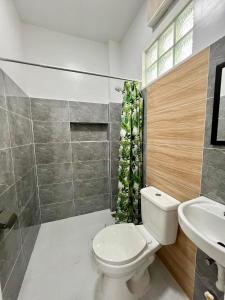 a bathroom with a toilet and a sink at Casa Mia Apartments in Villasis