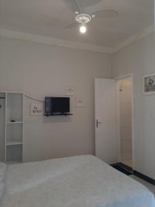 Un dormitorio con una cama y un televisor en la pared. en Aconchego e requinte flat Praia atalaia, en Aracaju