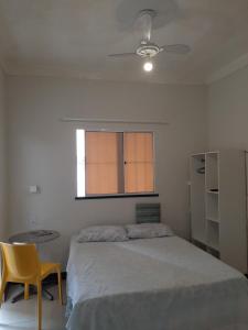Un dormitorio con una cama y una mesa y una ventana. en Aconchego e requinte flat Praia atalaia, en Aracaju