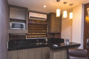 a kitchen with a sink and a microwave at CF Grand Central in Angeles