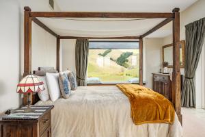 a bedroom with a large bed with a large window at Mountainview Villa Suite in an 6-bedroom Villa in Blenheim +20 photos