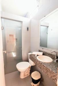 a bathroom with a toilet and a sink and a mirror at Pousada Central in Feira de Santana