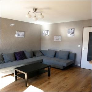 a living room with a blue couch and a table at 2 Alpes Les Bleuets in Les Deux Alpes