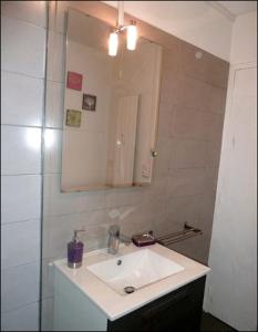een badkamer met een witte wastafel en een spiegel bij 2 Alpes Les Bleuets in Les Deux Alpes
