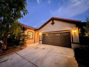 a house with a garage door and a driveway at The Greens, Golf, Pool & Arcade by Coachella in Indio