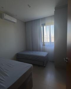 Una habitación de hotel con dos camas y una ventana. en Rivieira Santa Cristina XIII FJR, en Paranapanema