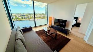a living room with a couch and a large window at Yarra Accommodation Private Apartment & Ensuite Room in Melbourne
