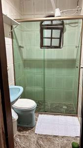 a bathroom with a toilet and a glass shower at La Mar Paraty Hospedaria 05 in Paraty