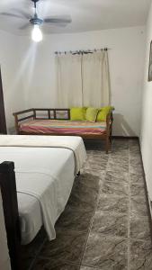 a bedroom with two beds and a window with yellow pillows at La Mar Paraty Hospedaria 05 in Paraty