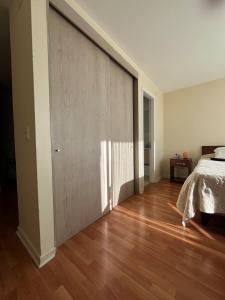 a bedroom with a bed and a wooden floor at departamento en osorno in Osorno +17 photos