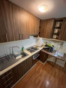 a small kitchen with wooden cabinets and a sink at departamento en osorno in Osorno