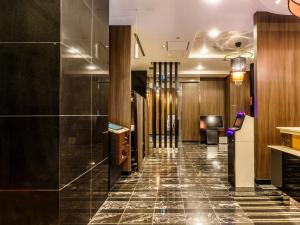 a hallway of a hotel lobby with a tile floor at APA Hotel Shibuya Dogenzakaue in Tokyo