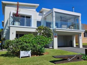 a large white house with a sign in front of it at Werri Big Beach House in Gerringong