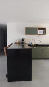 a kitchen with a black island in a room at Maravilhosa casa linear 5 suítes em Angra in Angra dos Reis