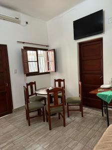 Un comedor con mesa y sillas y un televisor de pantalla plana. en Don David, en Salta
