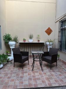 un patio con sillas y una mesa con macetas. en Don David, en Salta