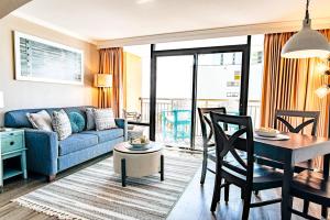 a living room with a blue couch and a table at Cool Coast Ocean View Resort Studio in Myrtle Beach