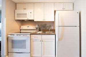 a kitchen with white cabinets and a white refrigerator at Cool Coast Ocean View Resort Studio in Myrtle Beach