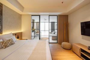 una habitación de hotel con una cama y un televisor en de' Asasta Apartment Benoa N-511, en Nusa Dua