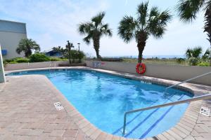 a large swimming pool with palm trees in the background at Ocean Front Escape with Lazy River in Myrtle Beach