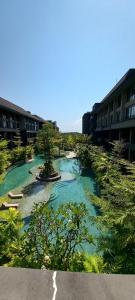 un cuerpo de agua al lado de algunos edificios en de' Asasta Apartment Benoa N-511, en Nusa Dua