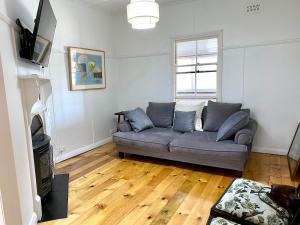 a living room with a couch and a television at The Merchant's Nook in Armidale