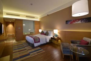 a hotel room with a bed and a living room at InterContinental Jaipur Tonk Road, an IHG Hotel in Jaipur