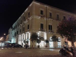 un gran edificio en una calle de la ciudad por la noche en B&B CARAVAGGIO SIRACUSA -200 Metres from Ortigia-, en Siracusa