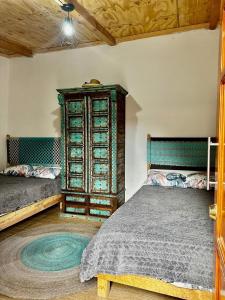 a bedroom with two beds and a wooden cabinet at Cabañas Rincón Metztitlán in Azolzintla