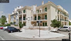 ein großes Gebäude, vor dem Autos parken in der Unterkunft Vilamoura - Apartment near Mariana & Falesia Beach in Quarteira