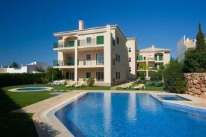 ein großes Haus mit einem davorliegenden Swimmingpool in der Unterkunft Vilamoura - Apartment near Mariana & Falesia Beach in Quarteira
