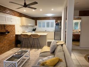a living room with a couch and a kitchen at Tallebudgera Creek Escape in Gold Coast