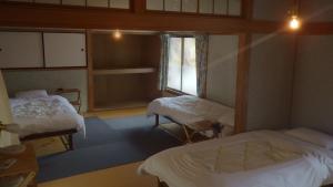 AkanoにあるCosmos Guesthouse Iya Valleyのベッド2台と窓のある病室です。