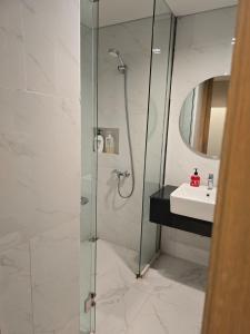 Un baño con ducha de cristal y lavabo. en de Asasta Apartment Benoa E-105, en Nusa Dua