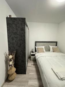 a white bedroom with a bed and a vase of flowers at Star in Varna City
