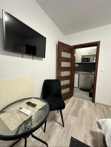 a room with a table and a chair and a television at Star in Varna City