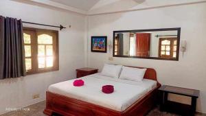 a bedroom with a bed with two red roses on it at VANESSA'S GARDEN Restaurant & Bungalow in PhumÄ­ AnlÃ³ng Svay