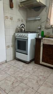 a kitchen with a stove with a tea kettle on it at Casa en Piriápolis in Piriápolis