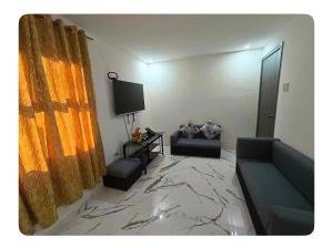 a living room with a couch and a television at La Casa Cita in Indang
