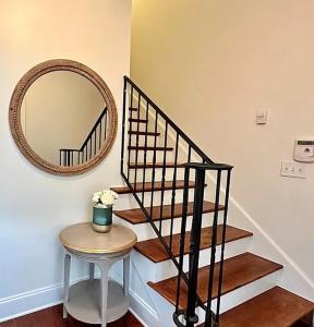 een trap met een spiegel en een tafel met een krukje bij Occasionally Oxford in Oxford