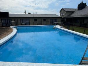 a large blue swimming pool in front of a house at Tokaanu Retreat in Turangi