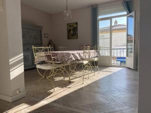 Charmant appartement lumineux et spacieux au centre de Royan - FR-1-738-44 في رويان: غرفة بها طاولة وكراسي ونافذة كبيرة